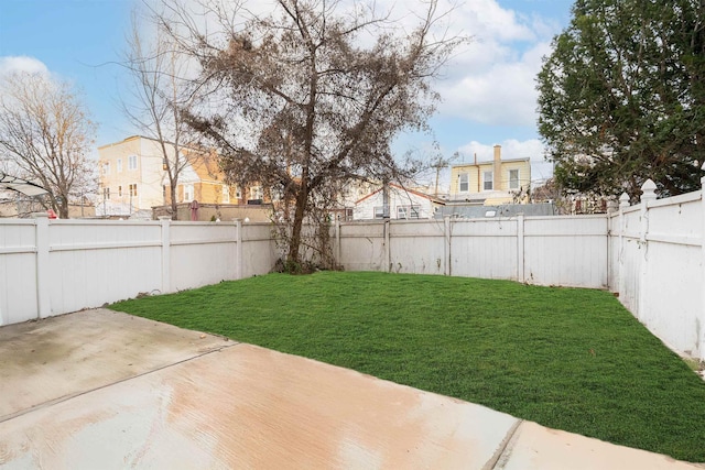 view of yard with a residential view, a patio area, and a fenced backyard