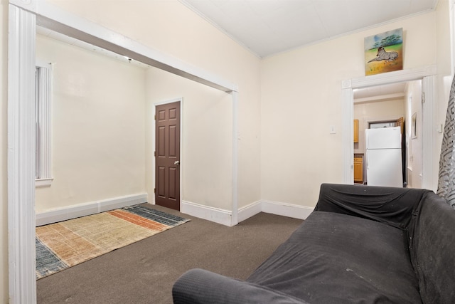 interior space with baseboards, ornamental molding, and dark colored carpet