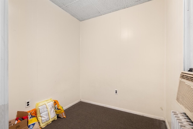 interior space featuring dark carpet and baseboards