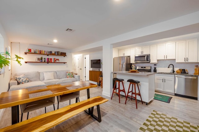 living room with sink and light wood-type flooring