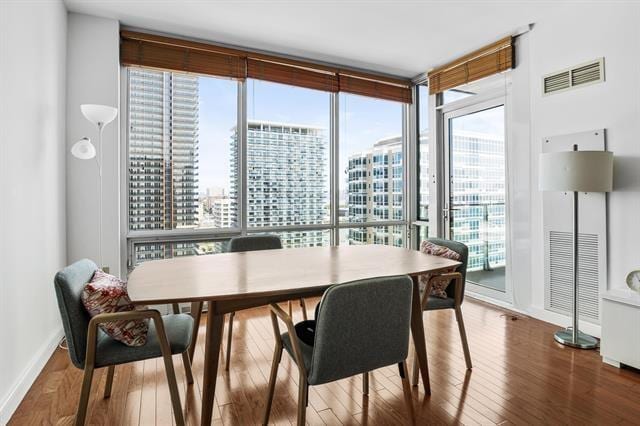 1 Shore Ln Unit 1805, Jersey City, NJ 07310 - dining room with wood finished floors, expansive windows, baseboards, and a city view