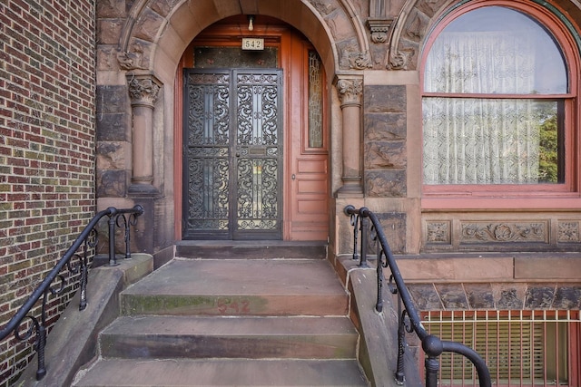 view of exterior entry featuring brick siding