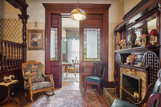 sitting room with a high end fireplace and wallpapered walls