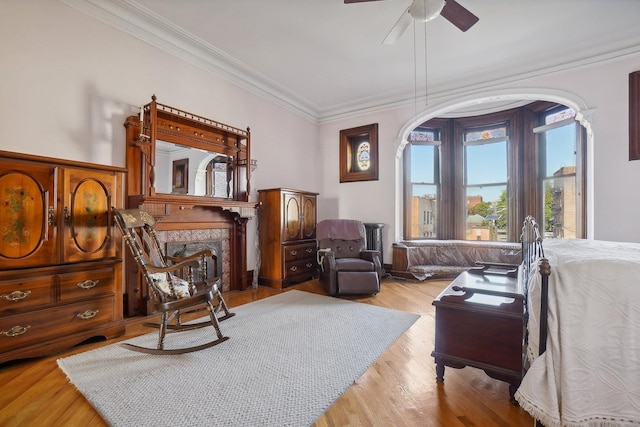 sitting room featuring ornamental molding, a ceiling fan, wood finished floors, and a premium fireplace