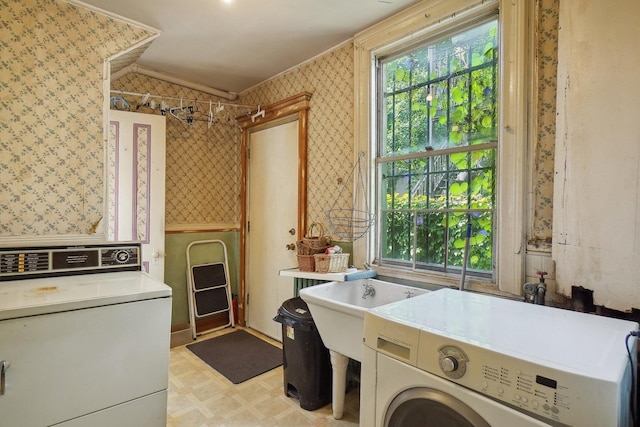 laundry room featuring laundry area, light floors, washing machine and clothes dryer, and wallpapered walls