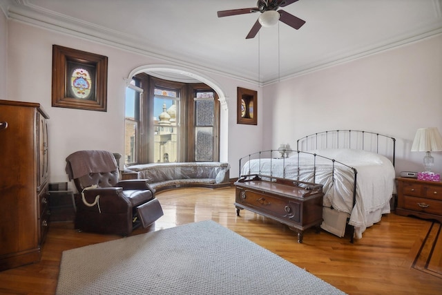 bedroom with ornamental molding, wood finished floors, and a ceiling fan