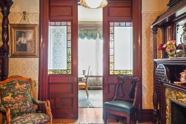 sitting room featuring a fireplace and wallpapered walls