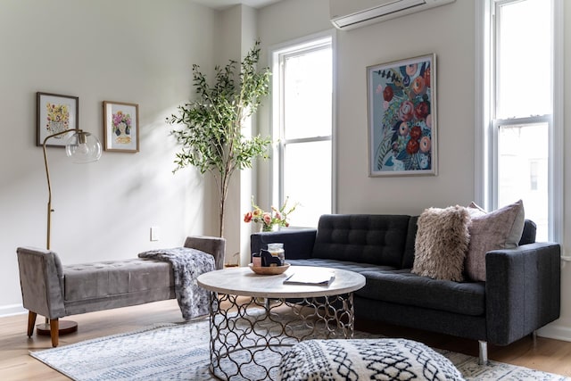 living area featuring hardwood / wood-style floors and a wall unit AC