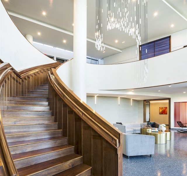 stairs featuring a towering ceiling and an inviting chandelier