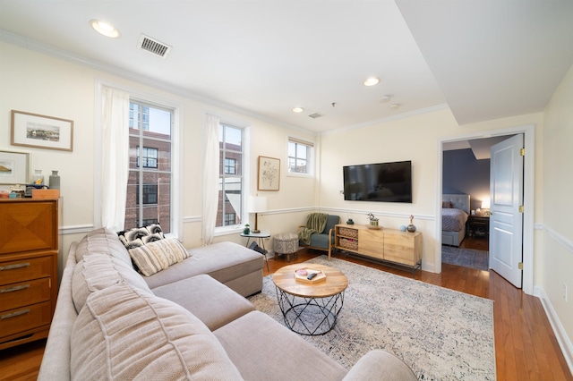 living room featuring visible vents, recessed lighting, crown molding, and wood finished floors