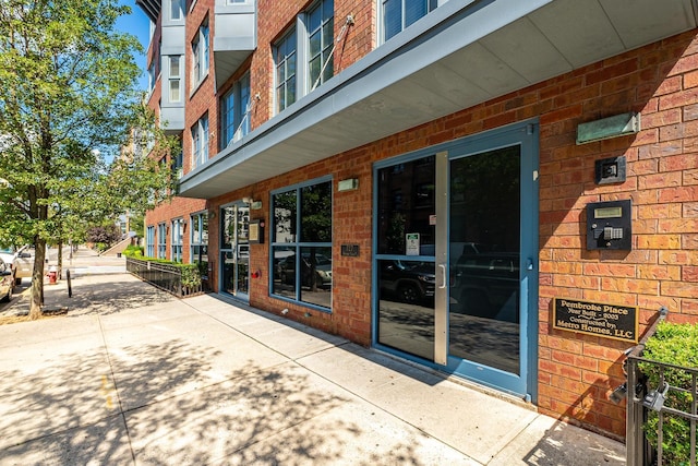 entrance to property featuring brick siding