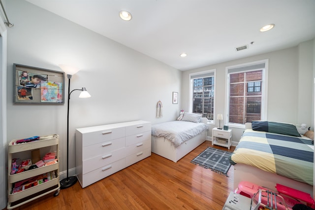 bedroom featuring recessed lighting, wood finished floors, visible vents, and baseboards