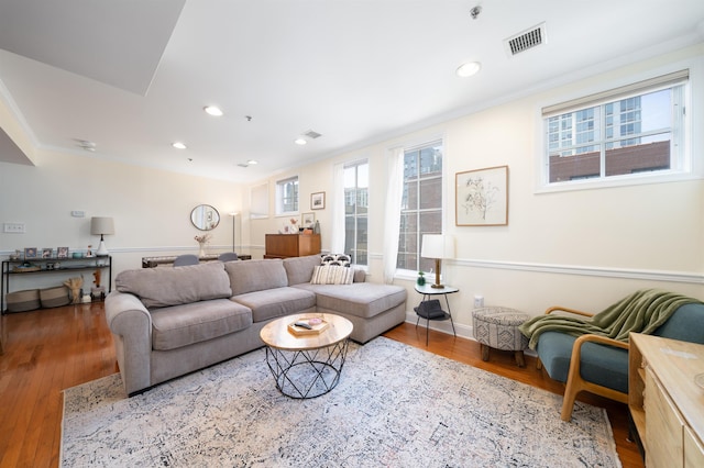 living room featuring visible vents, recessed lighting, crown molding, and wood finished floors