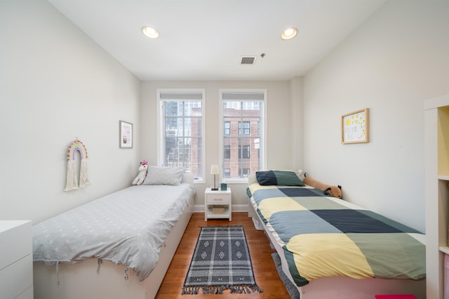 bedroom with recessed lighting, wood finished floors, visible vents, and baseboards