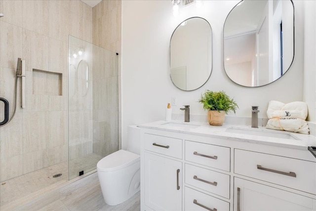 bathroom with a shower with shower door, toilet, and vanity