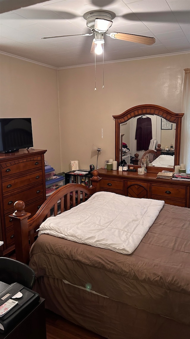 bedroom featuring hardwood / wood-style flooring, ceiling fan, and ornamental molding