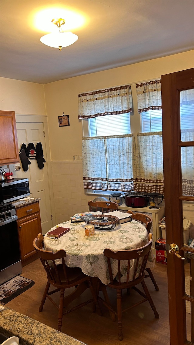 dining space with tile walls and hardwood / wood-style floors