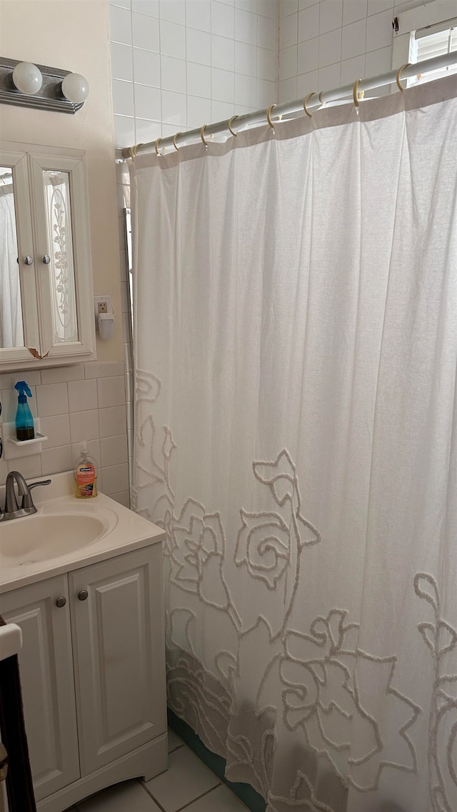 bathroom with tile walls, vanity, decorative backsplash, tile patterned flooring, and curtained shower