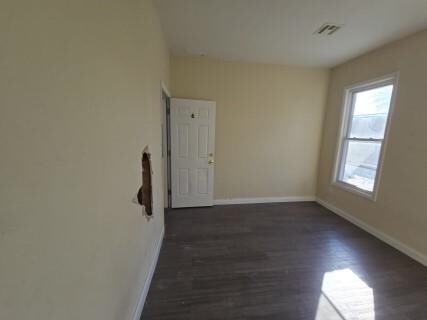 529 Communipaw Ave, Jersey City, NJ 07304 - unfurnished room with baseboards and dark wood-style floors