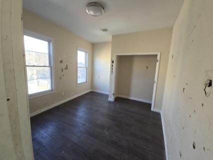 spare room with dark hardwood / wood-style floors and a wealth of natural light