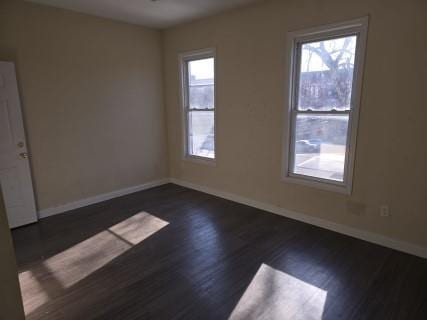 empty room featuring dark hardwood / wood-style flooring and a healthy amount of sunlight