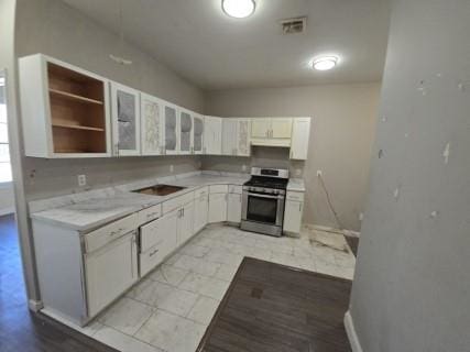 kitchen with white cabinets, stainless steel range oven, and light stone counters