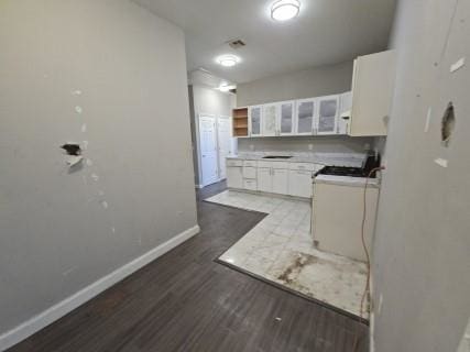 529 Communipaw Ave, Jersey City, NJ 07304 - kitchen featuring white cabinetry, wood finished floors, glass insert cabinets, and light countertops
