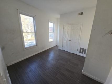 unfurnished room with dark hardwood / wood-style flooring and a wealth of natural light