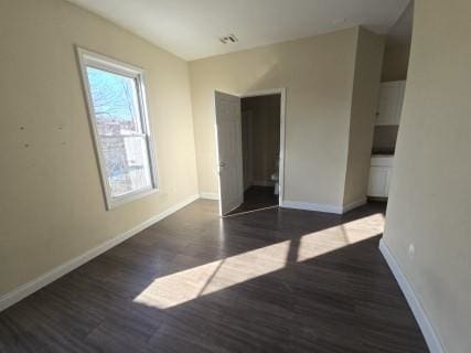 spare room with dark hardwood / wood-style flooring