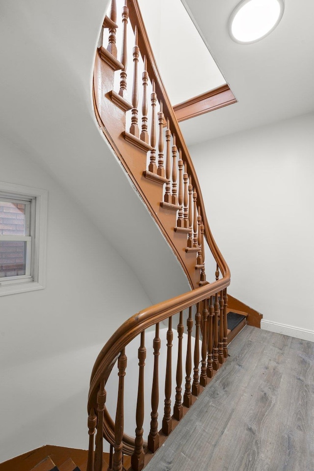 staircase with baseboards and wood finished floors