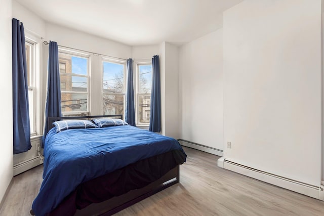 bedroom with a baseboard heating unit and multiple windows