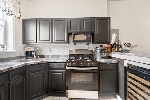 kitchen featuring a sink, wine cooler, tasteful backsplash, and black appliances