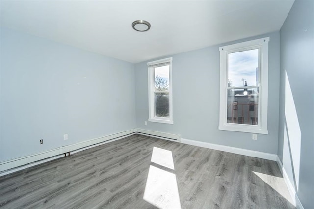 unfurnished room with baseboards and wood finished floors