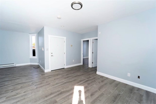 unfurnished living room featuring baseboards and wood finished floors