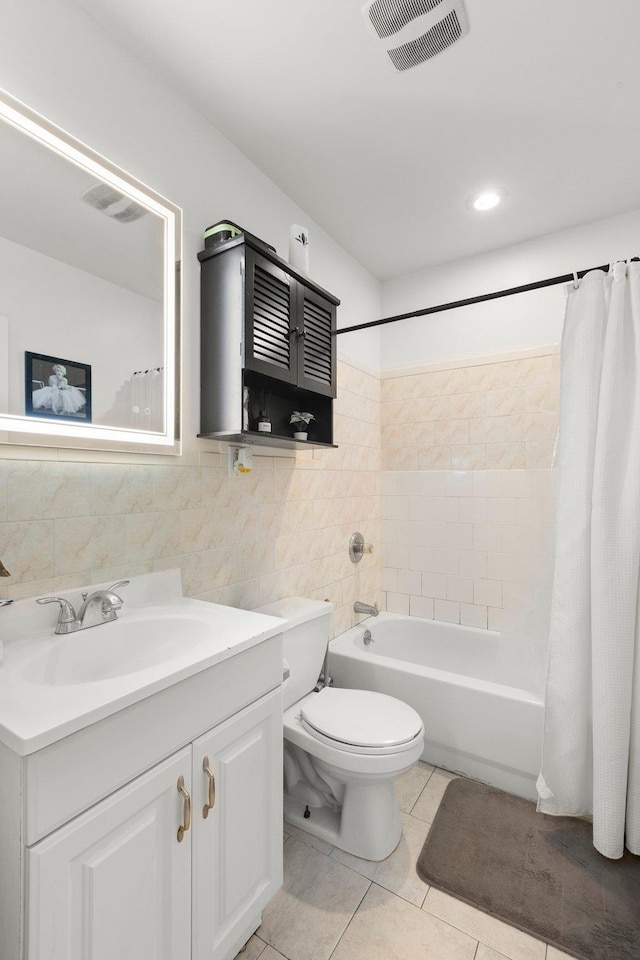 full bathroom with vanity, visible vents, tile walls, tile patterned floors, and shower / tub combo with curtain