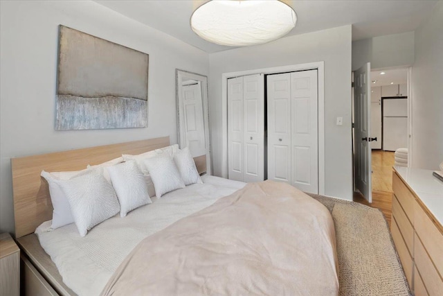 bedroom with white fridge and light hardwood / wood-style floors