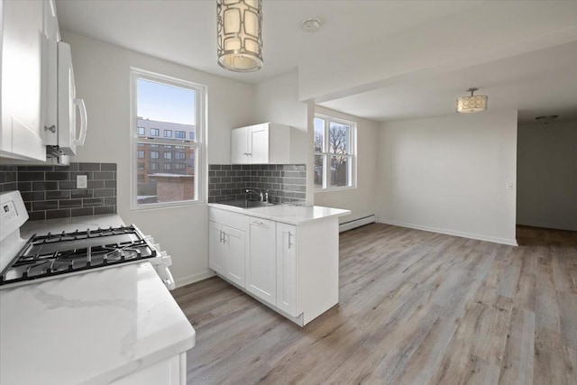 kitchen with sink, white appliances, decorative backsplash, and white cabinets