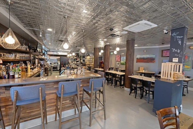 bar with pendant lighting and concrete floors