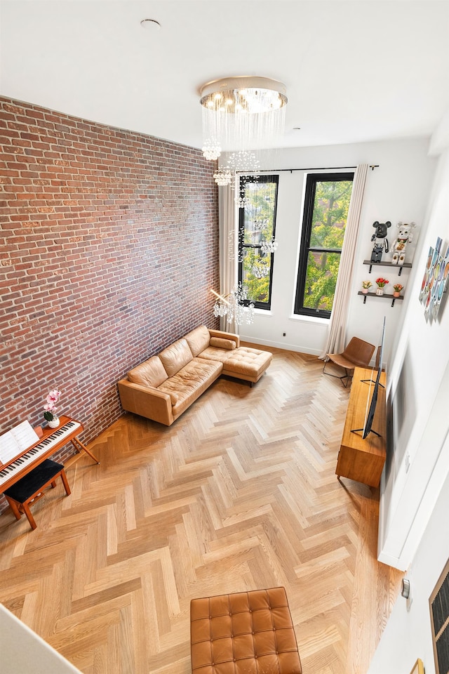 unfurnished living room with brick wall, a chandelier, and parquet floors