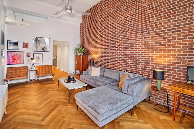 living room featuring brick wall, light parquet flooring, and ceiling fan