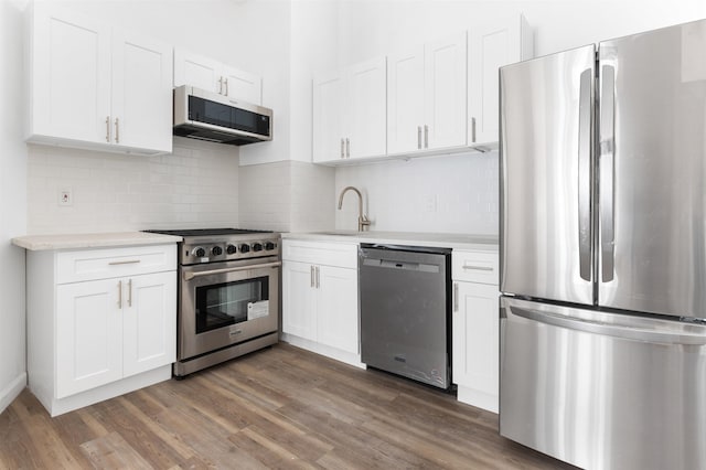 kitchen featuring light countertops, white cabinets, appliances with stainless steel finishes, and a sink