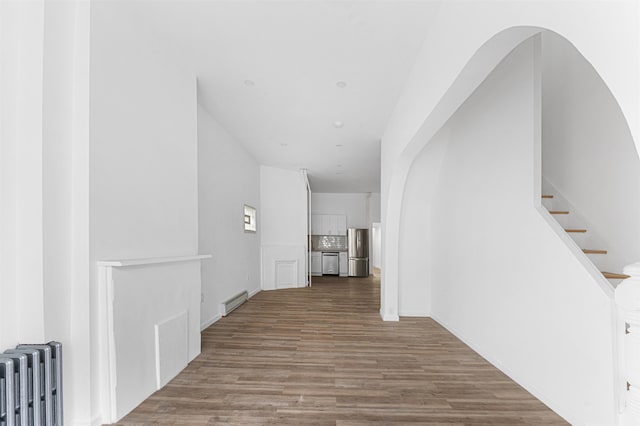 hall featuring a baseboard radiator, radiator, stairway, and wood finished floors