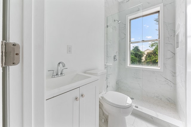 bathroom featuring a marble finish shower, toilet, and vanity