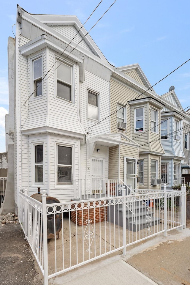 multi unit property featuring a fenced front yard and cooling unit