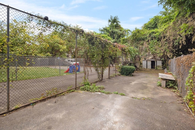 view of patio with an outbuilding, a storage shed, and fence