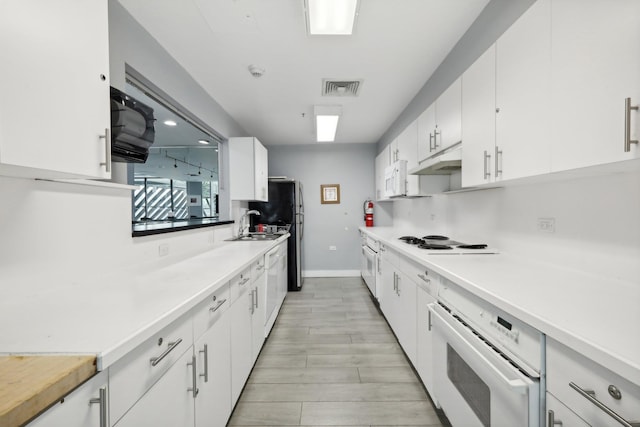 kitchen featuring white cabinets, white appliances, and sink