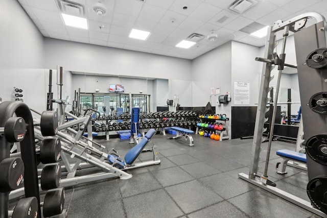 gym featuring a paneled ceiling and a high ceiling