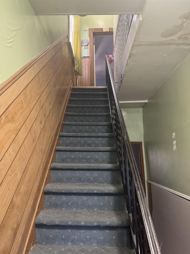 stairs featuring wood walls