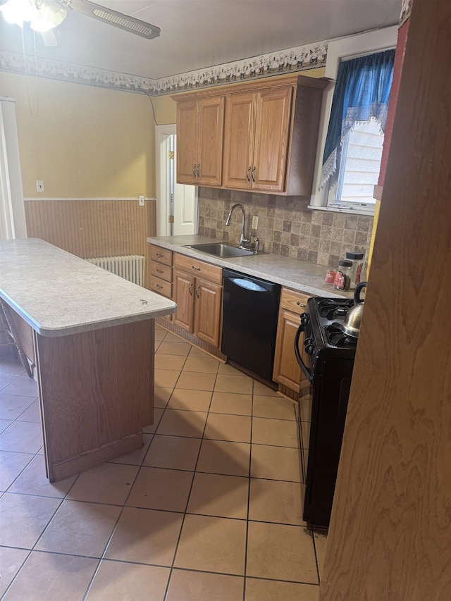 kitchen with ceiling fan, sink, a kitchen island, and black appliances