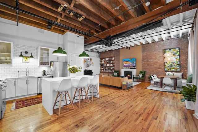 kitchen featuring light wood-type flooring, stainless steel appliances, a sink, and light countertops